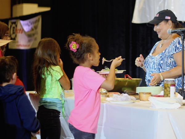 Children tasting food at a cooking demo.