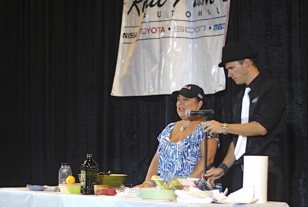 A man and woman adjusting a microphone at a cooking demo