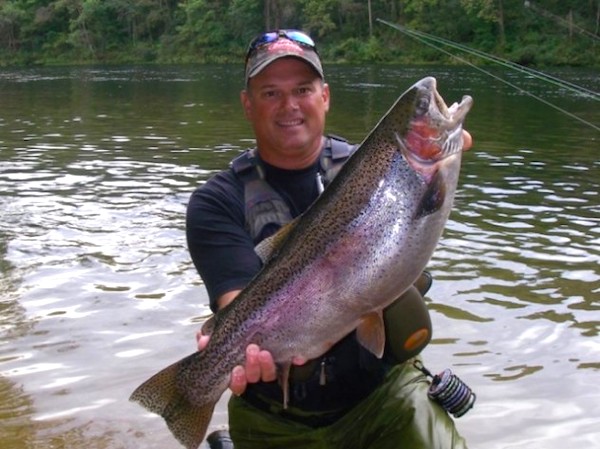 A man holding a big fish in a lake from Autumn Adventures in Branson MO