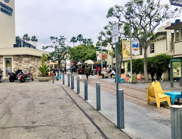 Original Farmers Market L.A. entry with colorful tables and chairs.