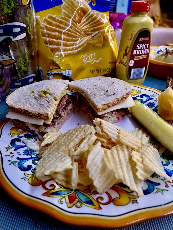 Colorful plate topped with a pastrami on rye, pickles and potato chips from Canter's Deli on Fairfax