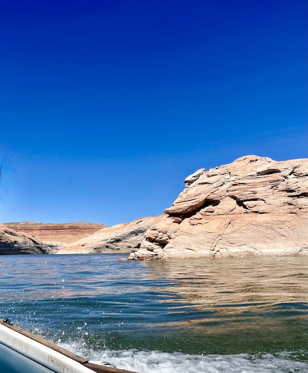 Spray from a boat on Spectacular Lake Powell Utah with pink and white rock formations