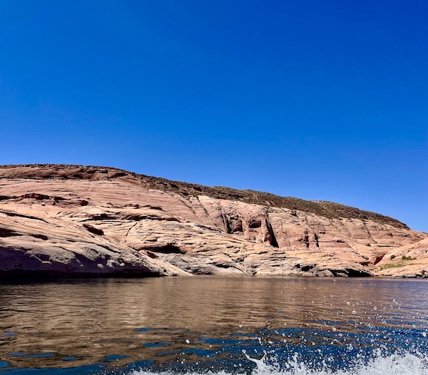 Rock formation in the lake that appears to have a face partially hidden by more rock.