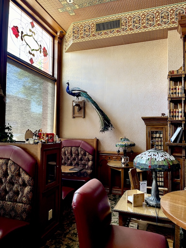 Dark red and wood booths and Tiffany lamps in the dining room of the Strater Hotel Durango Colorado