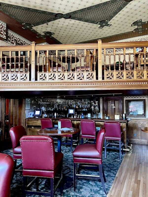 Dark red leather upholstered chairs and wood table at the steakhouse at Strater Hotel Durango Colorado