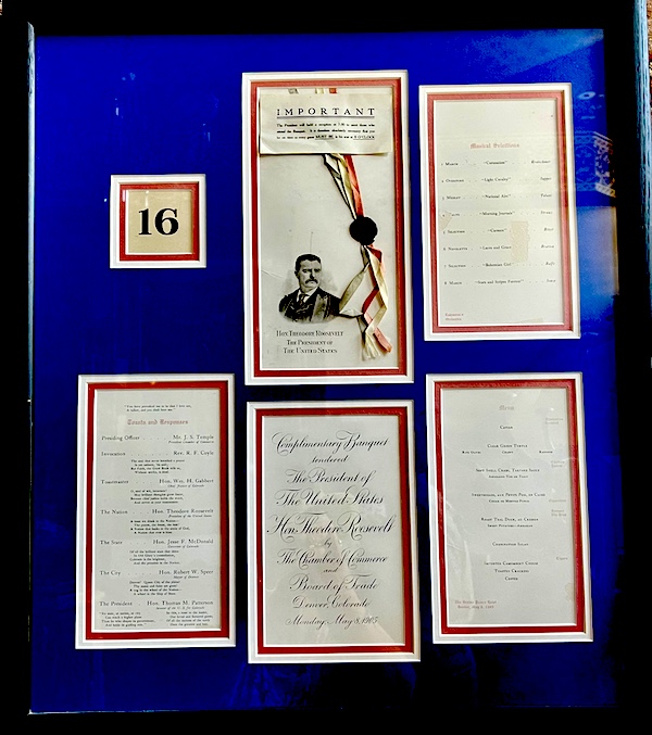 Menus on a bright blue background from a meal for Theodore Roosevelt at Strater Hotel Durango Colorado