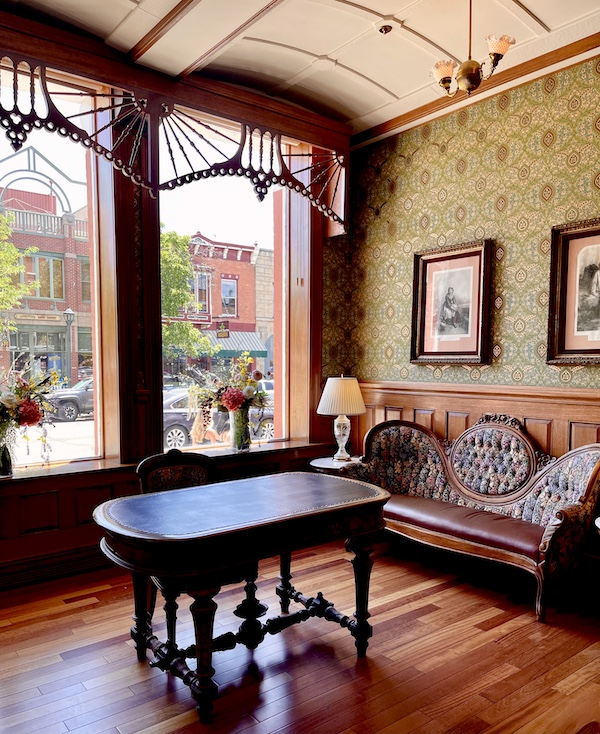 Strater Hotel Durango Colorado settee, lamps and tables with green print wallpaper.