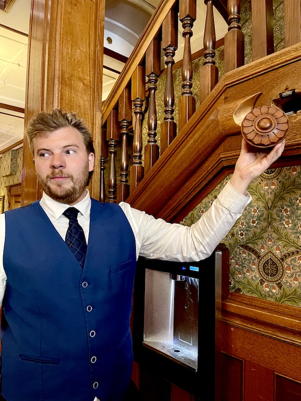 Man from front desk showing us a hidden compartment at the hotel