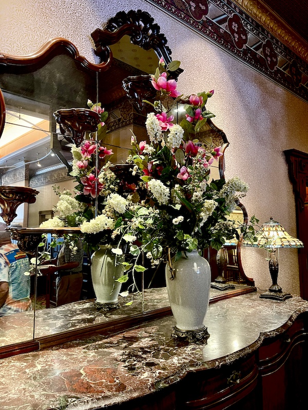 Vase of beautifully arranged flowers on a marble topped wood chest at the Strater Hotel Durango Colorado