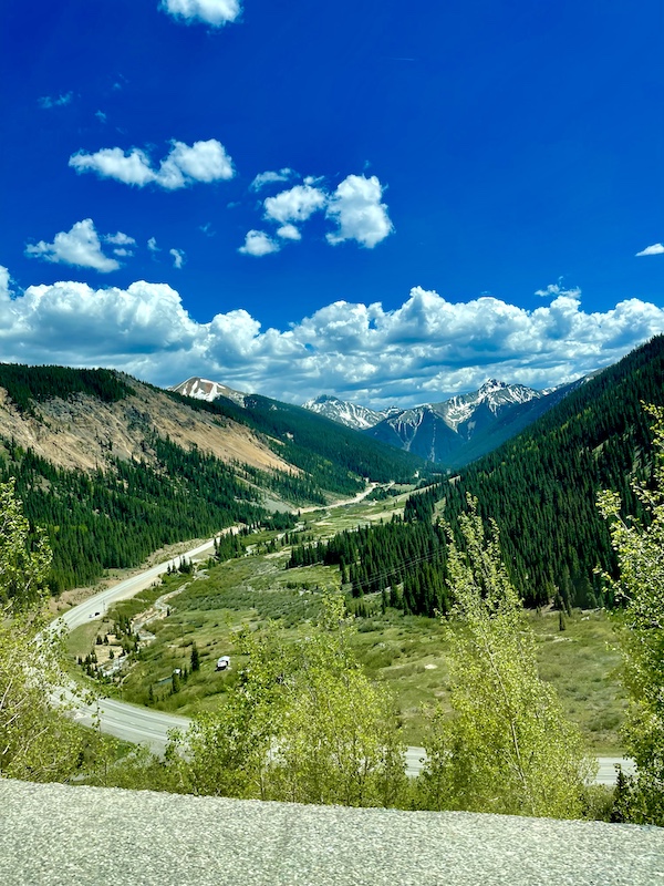 Tree covered mountains with snow streaked peaks in the distance