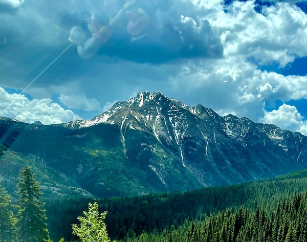 Storm cloud over a snow streaked mountain peak