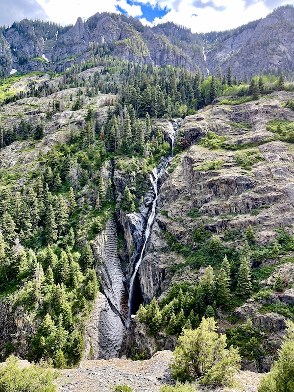 Snow melt forms a trickle of a waterfall down the mountain in Ouray