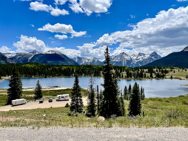 Mountain lake surrounded by trees with RVs parked seen on our Scenic Drive to Silverton and Ouray